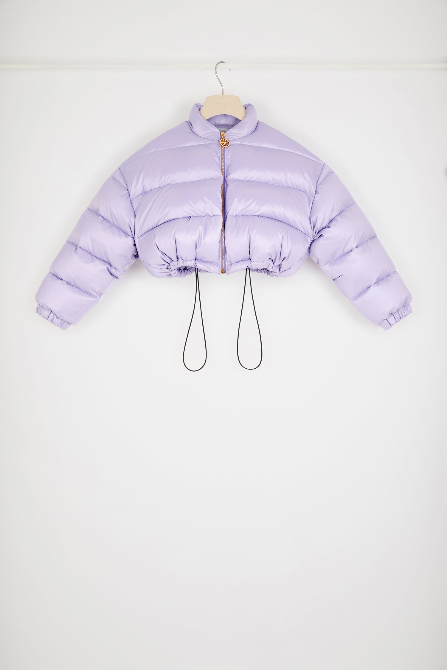 Patou - 파투 패딩 재킷 - Lavender - 파투로 이름 붙여진 패딩 재킷. 라벤더 컬러의 폴리에스터 혼방 소재 재킷. 짧은 기장의 패딩 재킷. 하이 칼라. 장 파투 아카이브의 헤리티지 키링에서 영감을 받은 JP 풀탭이 달린 골드 톤 지퍼. 뒷면의 라지 파투 로고. 측면 포켓. 드로스트링 웨이스트. 신축성 있는 커프스.