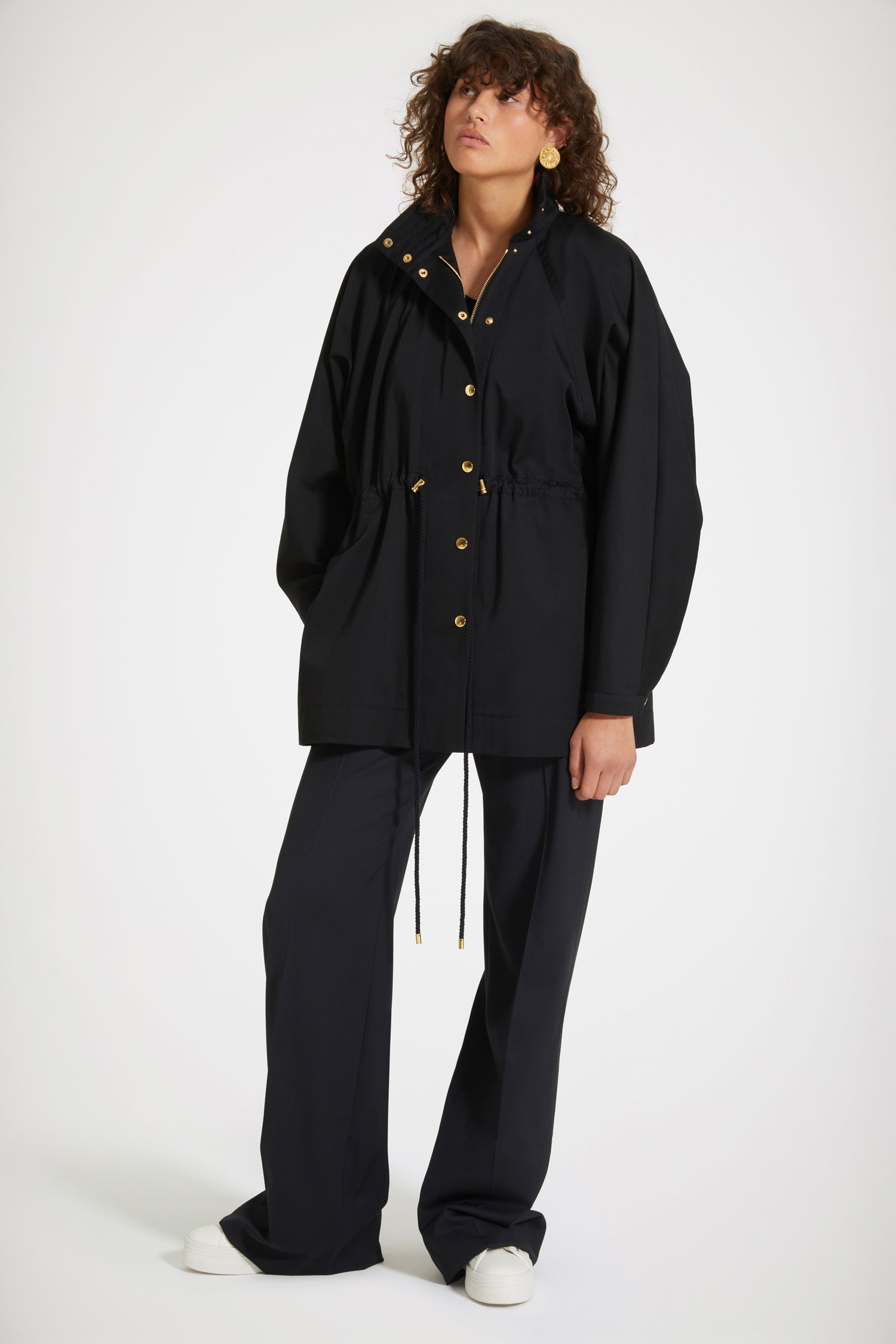 Patou - Parka en gabardine bio - Black - Une parka Patou que l&amp;#39;on aime plus que tout.Parka en gabardine de coton bio noir. Silhouette ample. Col montant avec détail de surpiqûres. Boutons pression dorés décentrés. Manches raglan chauve-souris avec pli au poignet. Taille coulissé avec liens en corde et détails en métal doré. Poches dans les coutures latérales. Patou et monogramme JP brodés au dos.