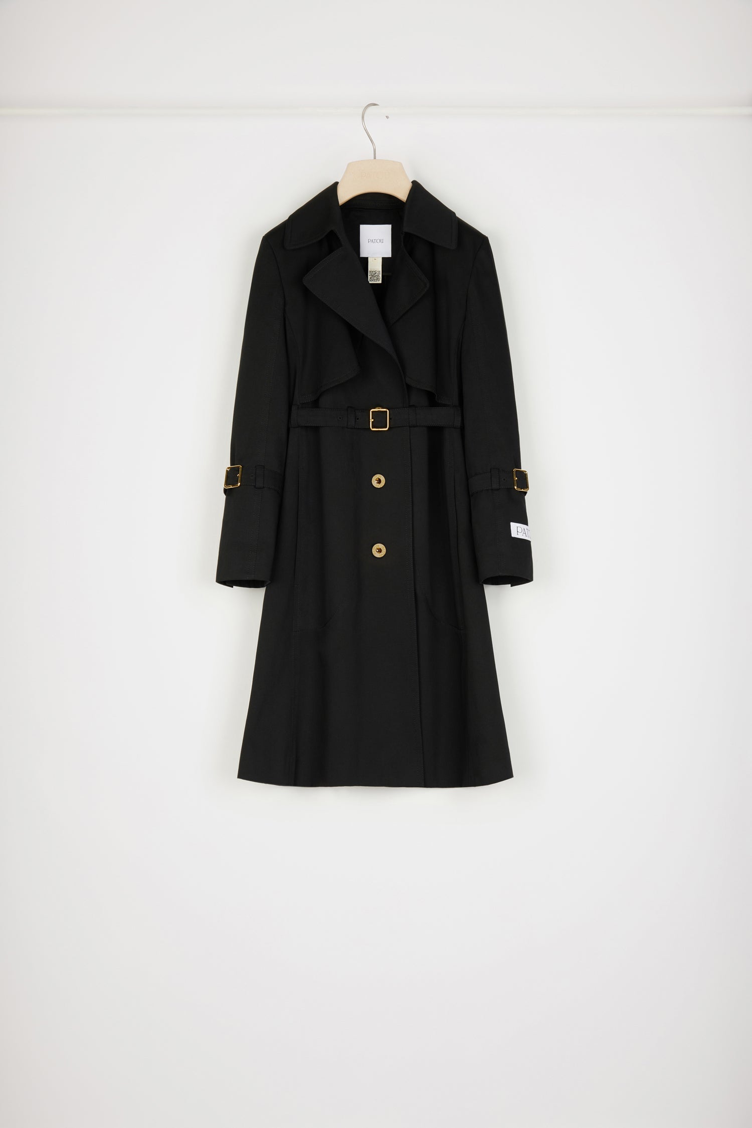 Patou - Trench coat in organic cotton gabardine - Black - How Patou fits and feels.Black organic cotton gabardine trench coat. Tailored single-breasted silhouette. Knee length. Notch lapels. Storm flap at the front. Gold-tone Patou-engraved buttons at the front. Adjustable gold-tone buckle belt that sits at the waist. Side seam patch pockets at the front. Belted cuffs. Signature Patou label on the left arm. Signature curved seam at the back. Single back vent with gold-tone Patou-engraved button.
