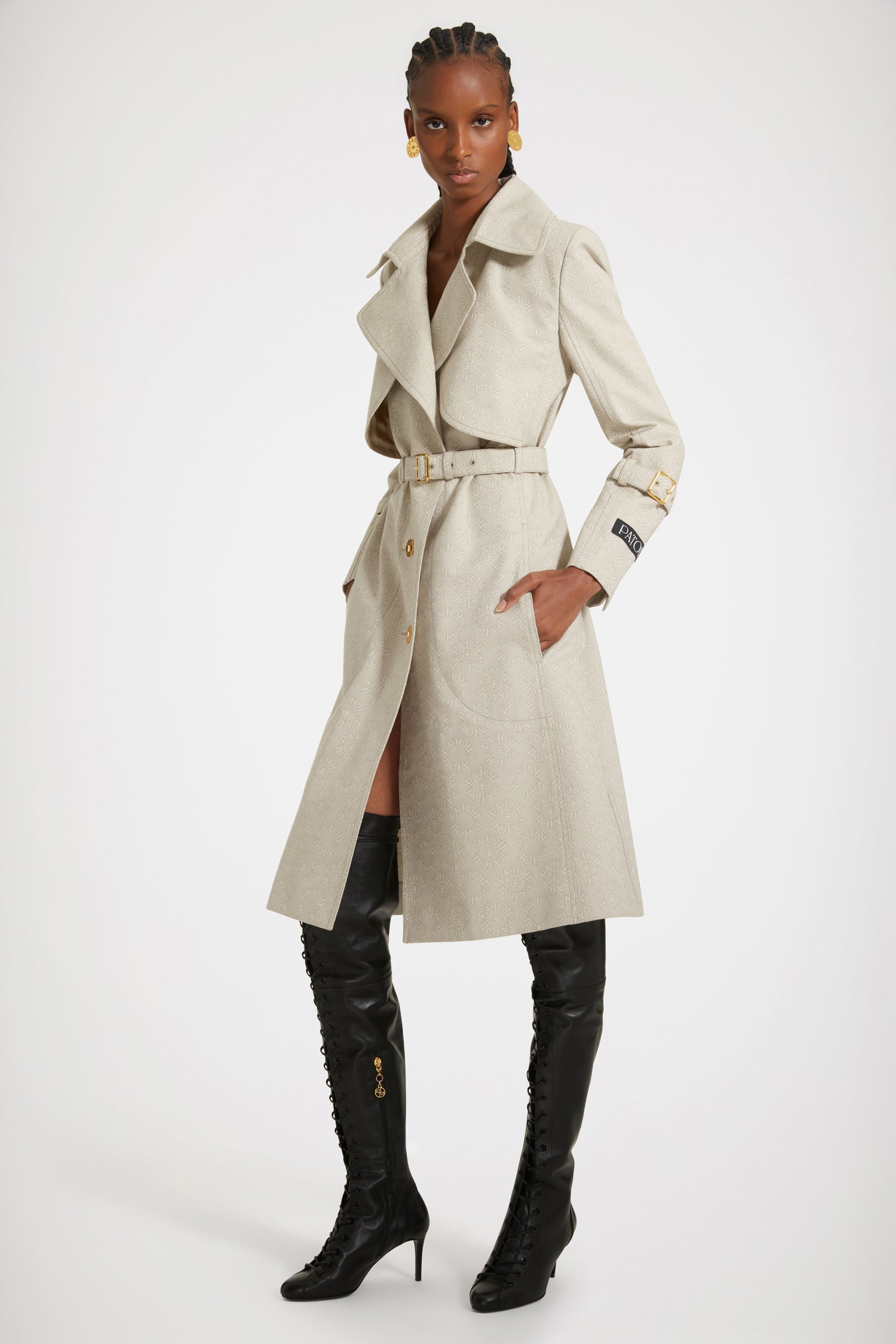 Patou - Trench in jacquard di cotone bio - Medallion - Patou firma il perfetto trench alla francese.Trench in jacquard di cotone bio. Fantasia Medaglione con logo Patou e monogramma JP. Modello monopetto. Lunghezza al ginocchio. Pattina frangivento sul davanti. Bottoni oro incisi Patou. Cintura regolabile con fibbia oro in vita. Tasche a toppa con apertura laterale. Polsini con cinturino. Etichetta Patou signature sulla manica sinistra. Cucitura curva signature sul retro. Spacco posteriore con bottone oro inciso Patou.Spring-Summer 2023 Show - Look #14