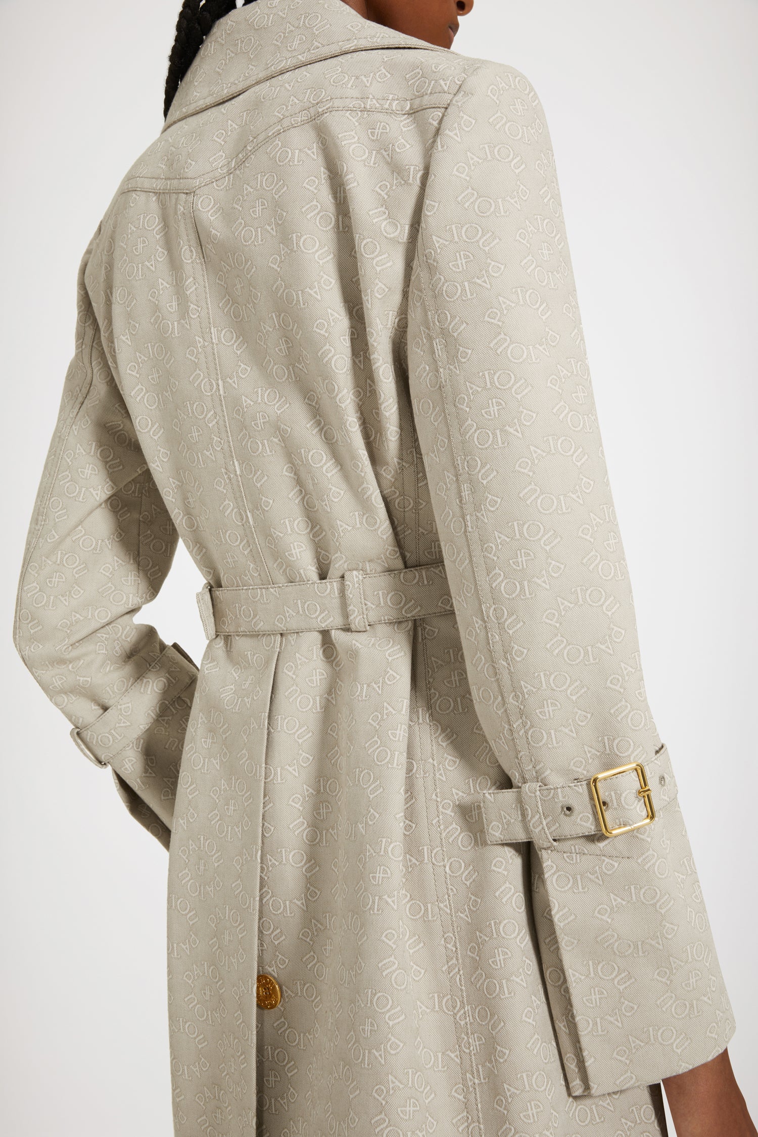 Patou - Trench in jacquard di cotone bio - Medallion - Patou firma il perfetto trench alla francese.Trench in jacquard di cotone bio. Fantasia Medaglione con logo Patou e monogramma JP. Modello monopetto. Lunghezza al ginocchio. Pattina frangivento sul davanti. Bottoni oro incisi Patou. Cintura regolabile con fibbia oro in vita. Tasche a toppa con apertura laterale. Polsini con cinturino. Etichetta Patou signature sulla manica sinistra. Cucitura curva signature sul retro. Spacco posteriore con bottone oro inciso Patou.Spring-Summer 2023 Show - Look #14