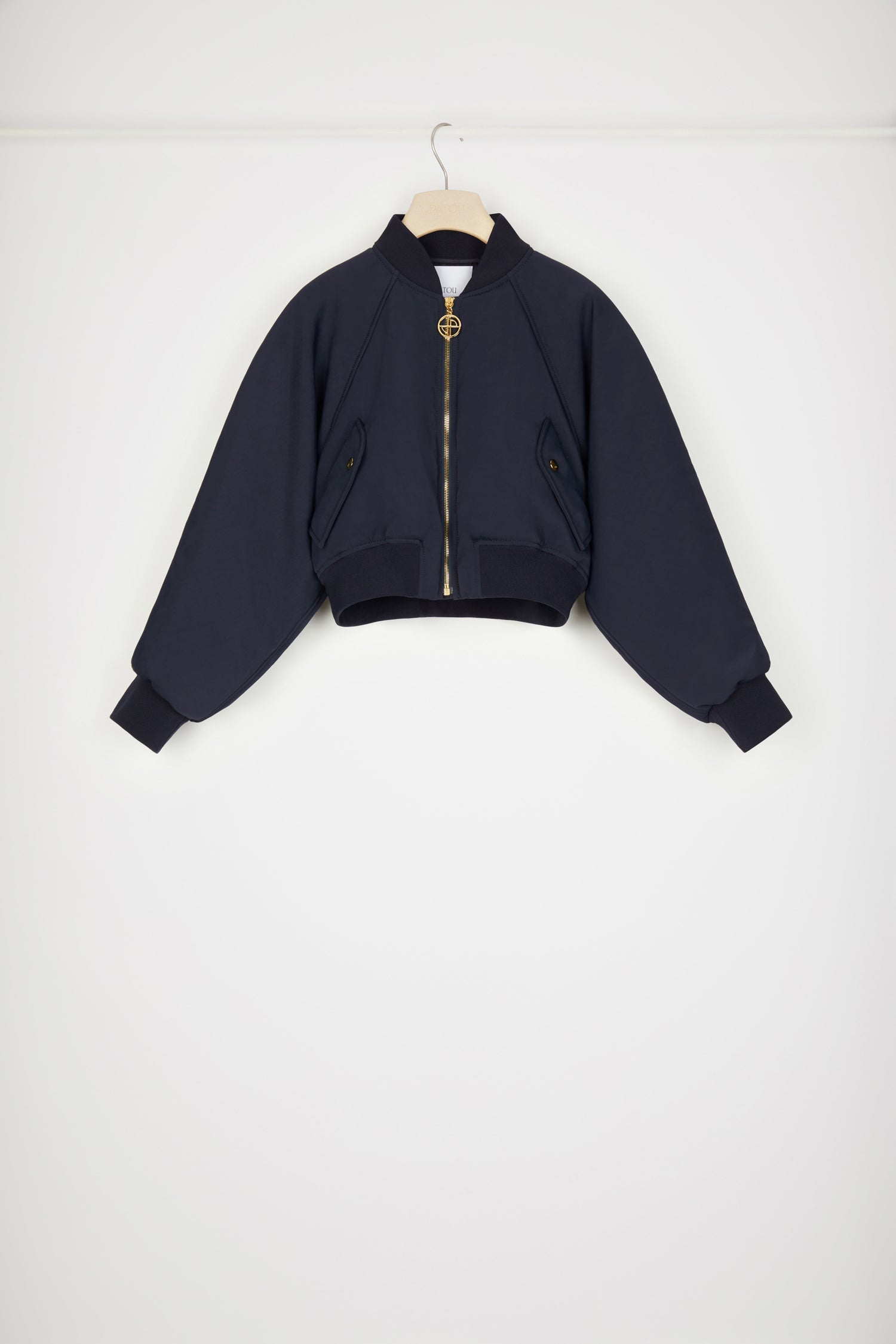 Patou - Cropped bomber jacket in recycled nylon - No Back Embroidery Navy - The bomber gets a Patou makeover. Night blue recycled tech nylon bomber. Cropped silhouette. Rib knit collar, cuffs and waist. Gold-tone zip fastening with signatue JP puller. Raglan sleeves. Diagonal pockets with gold-tone press buttons at the front.