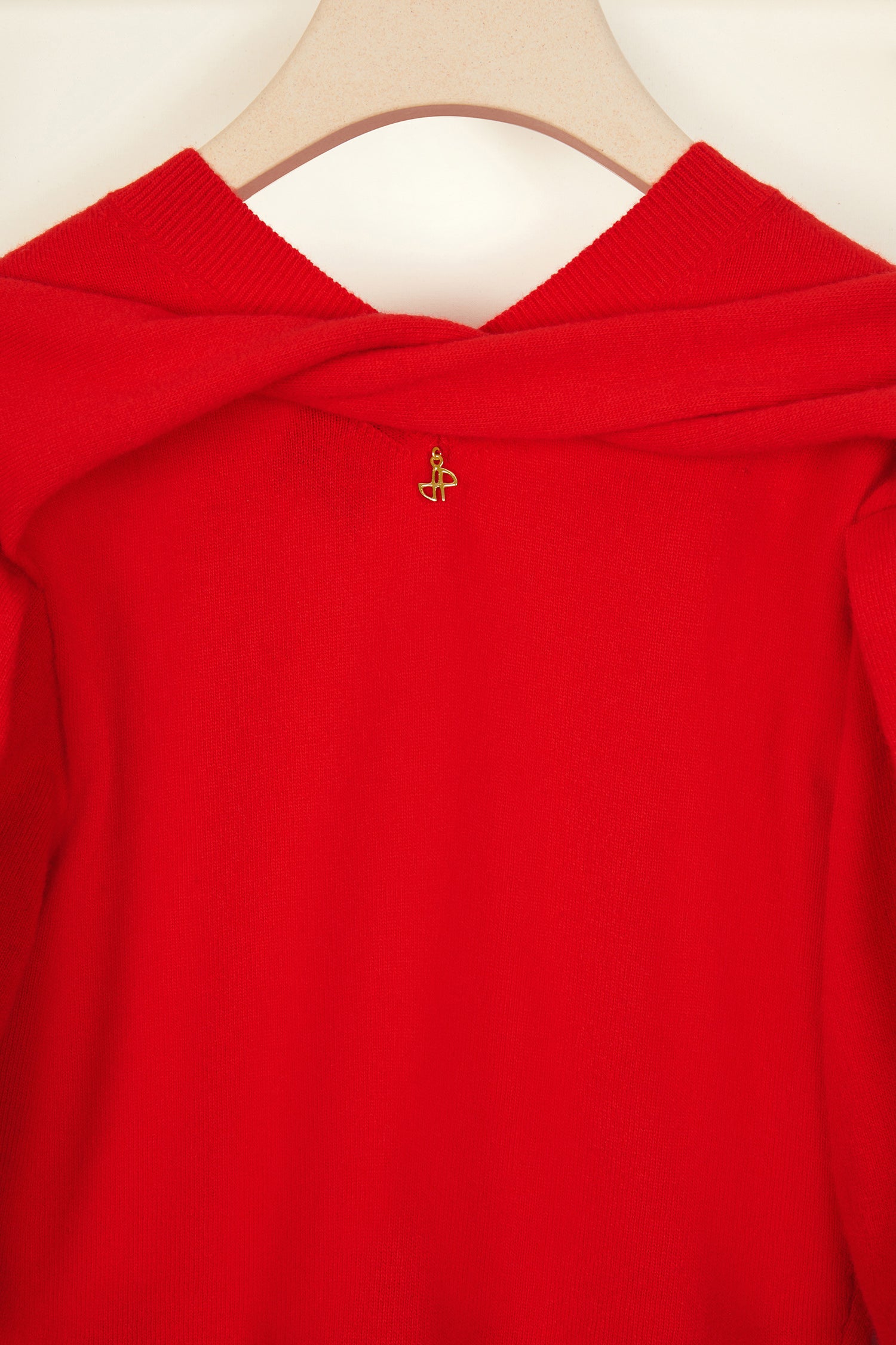 Patou - Wollpullover mit gedrehtem Kragen - Poppy - Strick in Bewegung.Mohnroter Wollpullover. V-Ausschnitt, hinten gedrehter Kragen. Goldfarbenes JP-Monogramm. Verkürzte, drapierte Ärmel.
