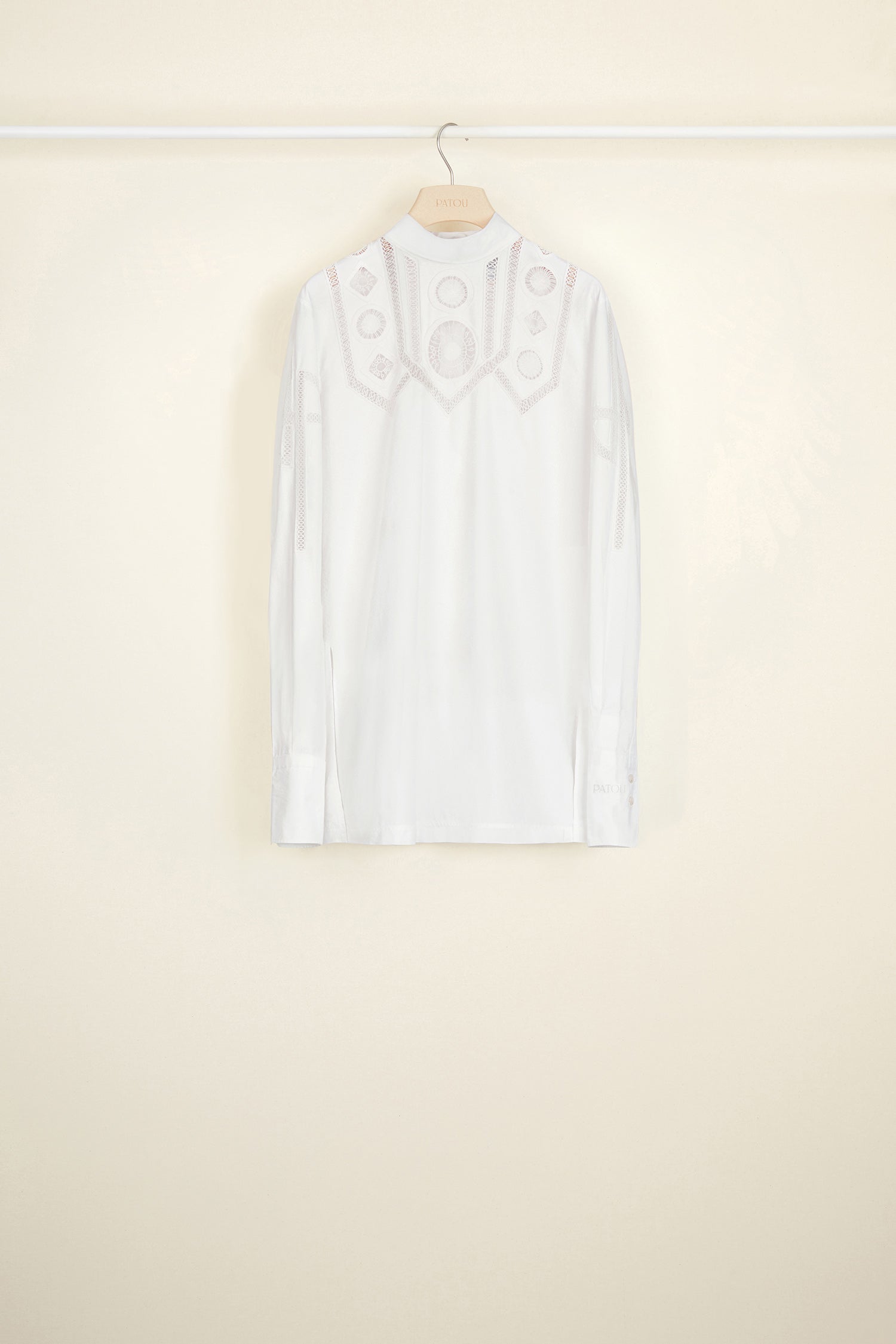 Patou - Guipure cut-out cotton top - White - The elaborate art of embroidery.White cotton poplin top with asymmetrical white guipure cut-outs at the front. High collar with button fastening at the back. Cut-out JP logo on both sleeves. Buttoned cuffs with embroidered Patou logo on the left sleeve. Side slits.