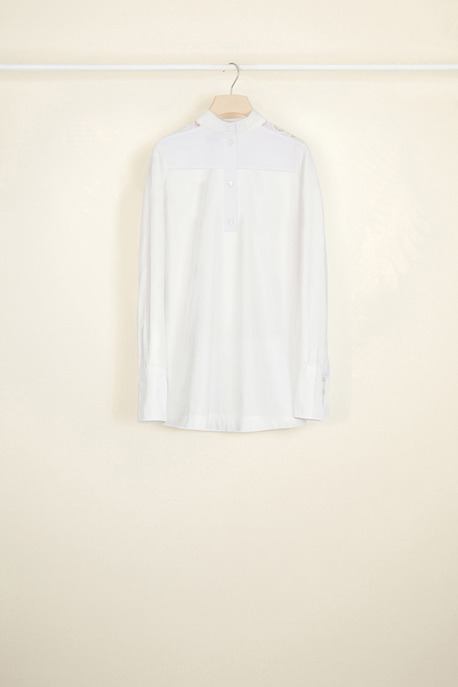 Patou - Guipure cut-out cotton top - White - The elaborate art of embroidery.White cotton poplin top with asymmetrical white guipure cut-outs at the front. High collar with button fastening at the back. Cut-out JP logo on both sleeves. Buttoned cuffs with embroidered Patou logo on the left sleeve. Side slits.