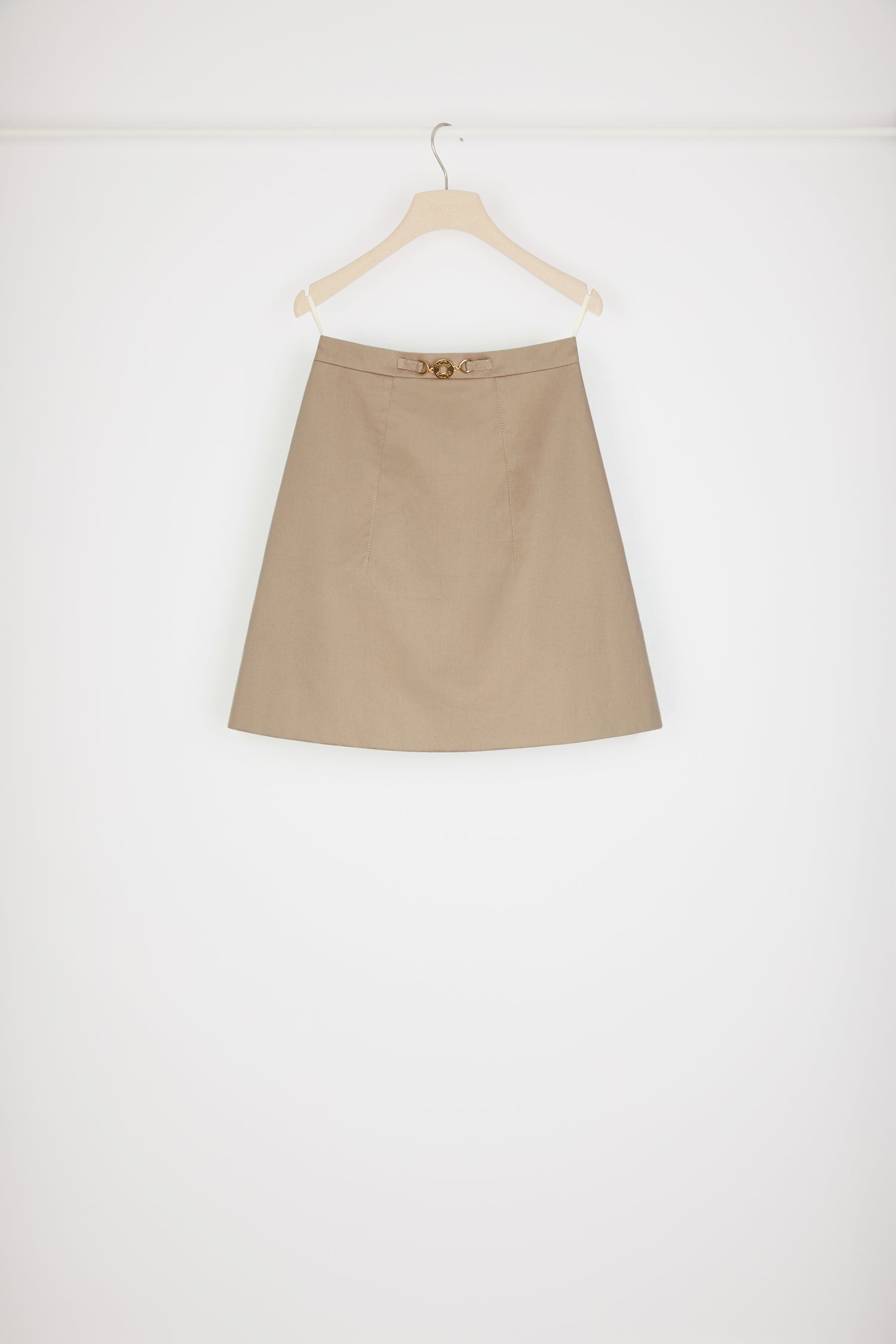 Patou - オーガニックコットン製メダイヨン ミニスカート - Parchment - Aラインの「A」dorable（愛らしい）シルエット。パーチメントベージュカラーのオーガニックコットンギャバジン製スカート。ショート丈。Aラインシルエット。フロントにゴールドトーンのパトゥ刻印入りメダイヨン装飾。フロントとバックにダーツ。バックにファスナー。 The ornament can be removed.