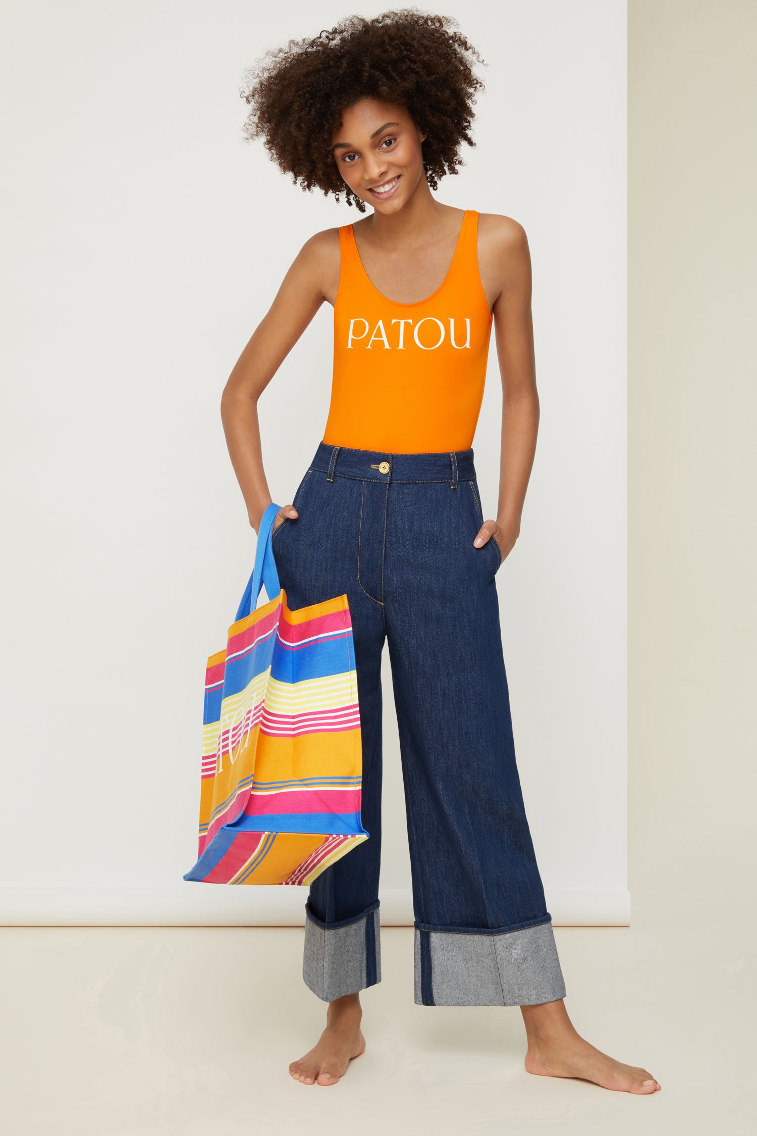Patou - Low back one-piece swimsuit - Citrus - Le swimwear by Patou.  Citrus orange stretchy one-piece swimsuit. Scoop neck, low back. White lettering logo at the front. Comes in an organic cotton drawstring pouch featuring the floral Indienne print in a new summery palette and the PATOU logo.