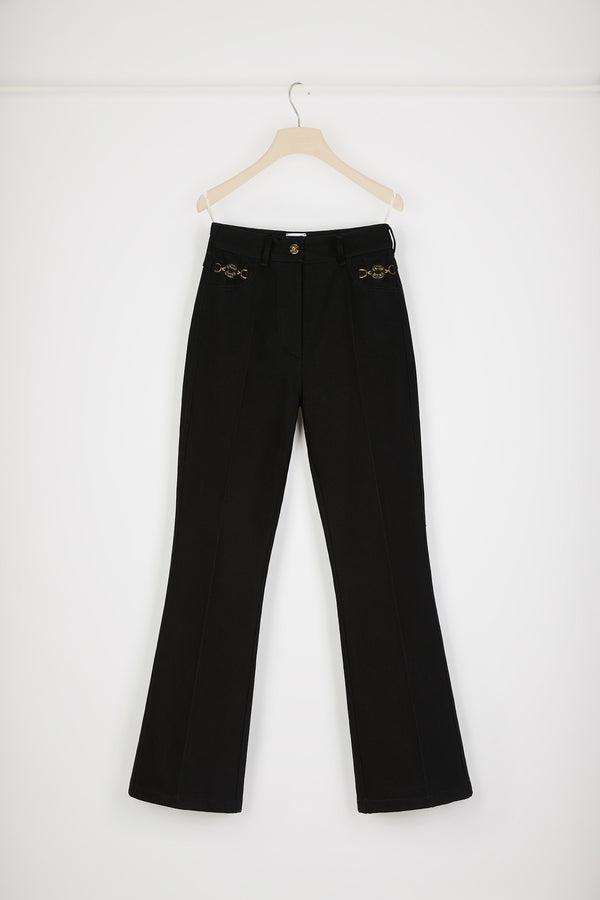 Patou - オーガニックコットンデニム製 フレアーパンツ - Black - ジャン・パトゥのアートが昇華された新しいパトゥデニム。ブラックカラーのオーガニックコットンデニム製パンツ。フレアーカット。ミッドライズ。フロントにゴールドトーンのパトゥ刻印入りボタン。ベルトループ付き。ウエストバンドにパトゥの刺しゅうロゴ。フロントとバックにダーツ使いとセンター位置の折り目。フロントにゴールドカラーのJP刻印入りオーナメントをあしらったポケット2つ。バックにブランドを象徴するカーブシーム。The ornament can be removed.