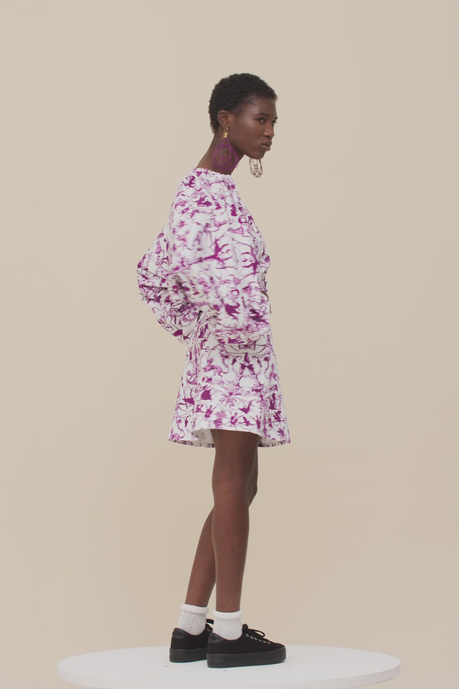 Patou - Elastisches Minikleid aus bedruckter Bio-Baumwolle - Stories And Tales - Eine Geschichte über kurze Säume und großes Volumen.  Kleid aus Bio-Baumwollpopeline mit dem „Stories and Tales“-Print der Saison. Kurz geschnitten. Elastischer V-Ausschnitt und Rücken. Voluminöse Ärmel mit elastischen Ärmelabschlüssen. Breiter größenverstellbarer Taillengürtel aus Stoff mit stoffbezogener Schließe und farblich abgestimmter Patou Logostickerei. Rockteil mit A-Linien-Schnitt.